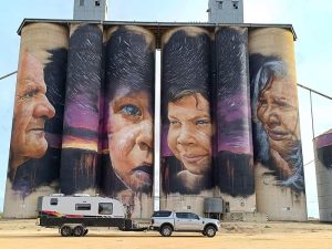 Ford Next-gen ranger towing a caravan in front of a mural painted on GrainCorp Silos at Sheep Hills, Victoria